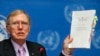 Michael Kirby, Chairperson of the Commission of Inquiry on Human Rights in North Korea holds a copy of his report during a news conference at the United Nations in Geneva, Feb. 17, 2014