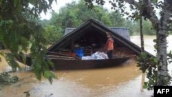 Một bé gái đứng trên chiếc thuyền ở phía trước ngôi nhà bị ngập ở Hà Tĩnh, ngày 5/10/2010. Tỉnh bị thiệt hại nhân mạng nặng nhất là Quảng Bình, với hơn 10 người chết. Nghệ An, Hà Tĩnh và Quảng Trị cũng bị thiệt hại nặng