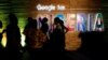 FILE — Participants walk past glowing signs during a conference tagged "Google for Nigeria" in Lagos, Nigeria, July 27, 2017.