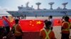 Pekerja pelabuhan Sri Lanka mengibarkan bendera nasional China di Pelabuhan Internasional Hambantota di Hambantota, Sri Lanka, Selasa, 16 Agustus 2022. (Foto: AP)