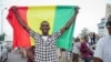 FILE - A man holds a national flag in the streets of Bamako, Mali, on Aug. 18, 2020. The Islamic State claimed that it killed 16 Malian soldiers the week of Aug. 3, 2023.