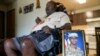 FILE — A portrait of American soldier Travis King is displayed near his grandfather, Carl Gates, in Kenosha, Wisconsin, July 19, 2023. Two days earlier, King dashed into North Korea while on a civilian tour of the Joint Security Area on the border between the two Koreas.  