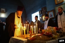 A church service is held for those killed in the Russian Il-76 military transport plane crash in the Belgorod region, in the village of Yablonovo near the crash site, on Jan. 24, 2024.