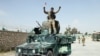 An Afghan soldier raises his hands as a victory sign, in Kunduz city, Oct. 2, 2015. 