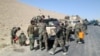 Members of Afghan security forces and volunteer militias break on their way to Kunduz, Afghanistan, to fight against Taliban militants, Oct. 1, 2015.