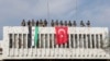 FILE - Turkish soldiers, right, and Turkey-backed opposition fighters stand atop a building next to their flags in Ras al Ayn, northeastern Syria, Oct. 23, 2019. 