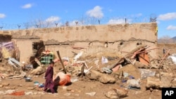 FILE - A boy walks inside what is left of a home in Kandahar province, south of Kabul, Afghanistan, March, 3, 2019. The U.N. Children's Fund is appealing for money to treat Afghanistan's malnourished children.
