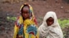 Girls, displaced by recent fighting between Congolese army and the M23 rebels, cover themselves from the cold in Munigi village near Goma in the eastern Democratic Republic of Congo, Sept. 1, 2013.