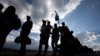 People are silhouetted against a late afternoon sun as they queue to see the remains of Nelson Mandela at the Union Buildings in Pretoria, South Africa, Dec. 11, 2013, where his body lies in state for three days.