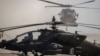 Helikopter Blackhawk mendarat di sebelah helikopter Apache di pangkalan militer AS di lokasi yang dirahasiakan di Suriah Timur, Senin, 11 November 2019. (Foto: AP)
