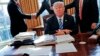 Presiden Donald Trump duduk di mejanya setelah pertemuan dengan CEO Intel Brian Krzanich, kiri, dan anggota stafnya di Oval Office Gedung Putih di Washington, 8 Februari 2017. (Foto: AP/Pablo Martinez Monsivais)