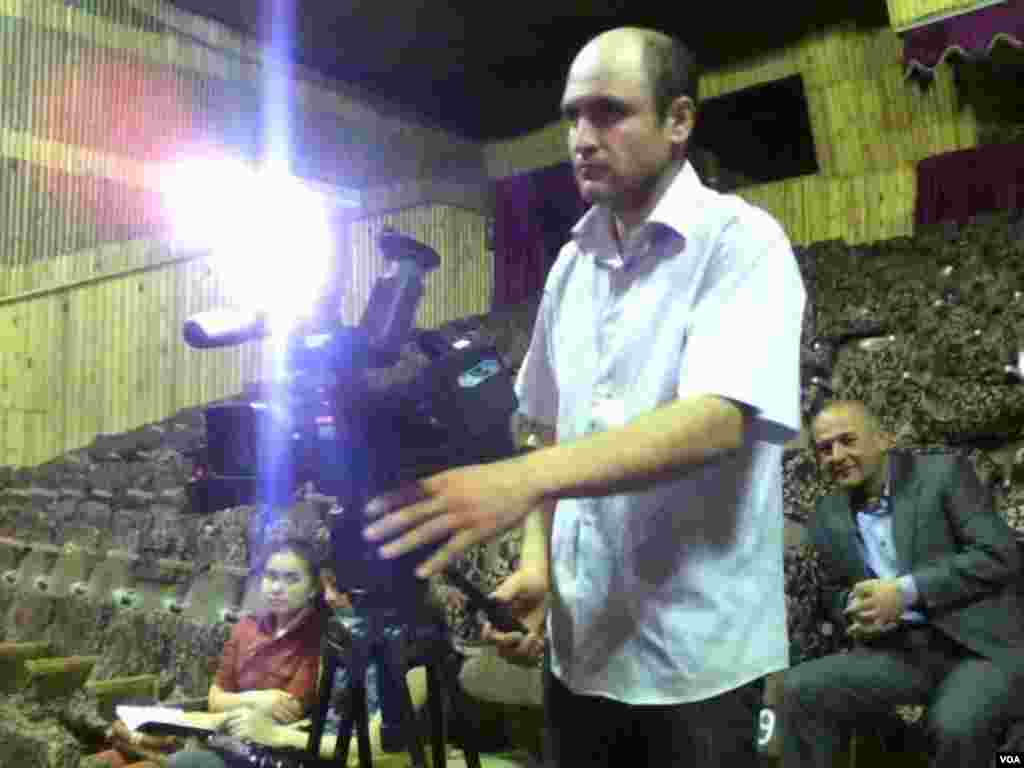 O'zbeklarning ijodiy kechasi oldidan zalda mahalliy televideniye operatori ishga hozirlik ko'rmoqda