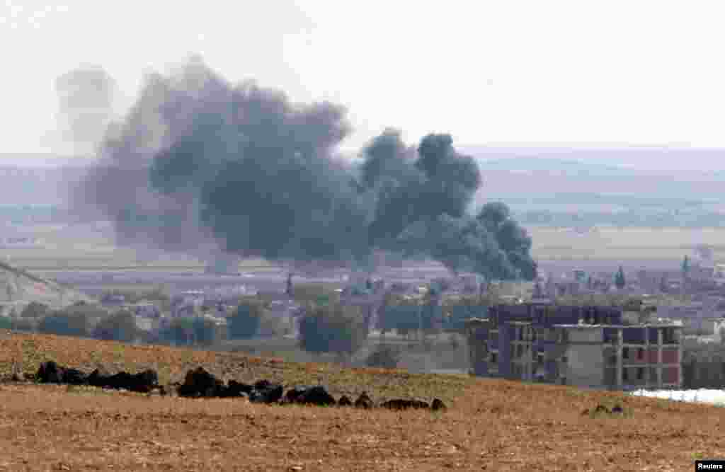 Suriyaning Turkiya chegarasi yaqinidagi Kobani shahridan quyuq qora tutun chiqmoqda, 6-oktabr, 2014-yil. 