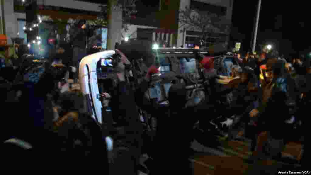 In a second night of violence following a grand jury&#39;s decision not to indict a white police officer in the shooting death of a black teenager, protesters attack and turn over a police car outside Ferguson City Hall, in Ferguson, Missouri, Nov. 25, 2014.