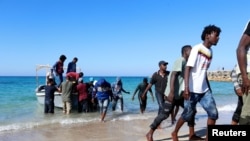 FILE - Migrants are seen after being rescued by the Libyan coast guard in Tripoli, Libya July 26, 2019. Two French charities pulled 81 migrants from the waters off Libya Sunday.