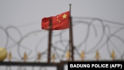 资料照：中国新疆喀什以南的一处围墙铁丝网后的中国国旗。（2019年6月4日）