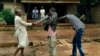 FILE - Muslim men organized in militias with machetes rough up a Christian man while checking him for weapons in the Miskine neighborhood of Bangui, Central African Republic, Dec. 13, 2013.