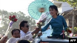 Các ủng hộ viên mang hoa tặng lãnh tụ dân chủ Miến Ðiện Aung San Suu Kyi trên đường đi vận động tranh cử tại thị trấn Thone-Gwa ở Yangon, ngày 26/2/2012