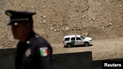 A Mexican police officer stands next to a bollard-type wall along the border of a private property, built using funds raised from a GoFundMe account, at Sunland Park, New Mexico, as a border patrol vehicle is seen, from Ciudad Juarez Mexico May 29, 2019…