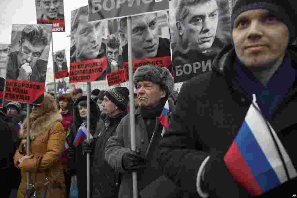 People carry portraits of opposition leader Boris Nemtsov, who was gunned down on Friday near the Kremlin, with words reading "He fought for a free of Russia, He fought for our future!" in Moscow, Russia, March 1, 2015. 