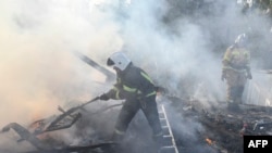 Donetsk şəhərində 24 oktyabr 2023-cü il tarixində Rusiyanın Ukraynada davam edən hərbi əməliyyatları fonunda yanğınsöndürənlər mərmilərin vurduğu, bir kişinin ölümü və bir qadının yaralanması ilə nəticələnən evdəki yanğınla mübarizə aparırlar. (Foto STRINGER / AFP)