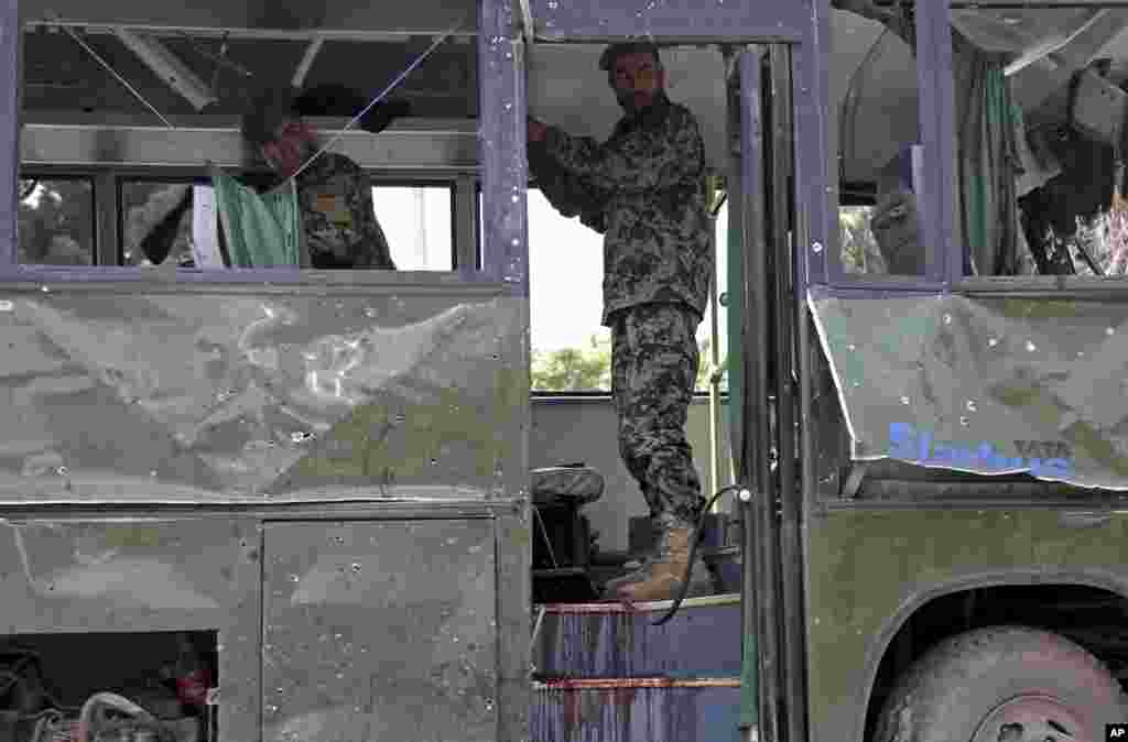 Afg&#39;on askarlari portlash oqibatida yaroqsiz holga kelgan avtobusni yo&#39;ldan olishga hozirlanmoqda, Kobul, 2-iyul, 2014-yil.