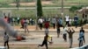 Protesters throw rocks at policemen during an attack on South African business, in Abuja, Nigeria, Sept. 4, 2019. 