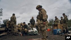 Фото: український військовий соїть на російському прапорі в Ізюмі, 13 вересня 2022 року.(AP Photo/Kostiantyn Liberov)