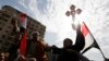 A Coptic Christian is seen holding up a cross during a rally in Cairo's Tahrir Square in this February 6, 2011, file photo.