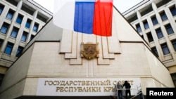 Qrimda ukraincha yozuvlar ruschaga almashtirildi, Ukraina bayrog'i o'rnida Rossiya bayrog'i hilpiramoqda, Simferopol, 19-mart, 2014-yil.