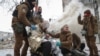 Medical workers treat a wounded local resident at a site of residential buildings heavily damaged during a Russian missile attack, amid Russia's attack on Ukraine, in Kharkiv, Ukraine Jan. 23, 2024.