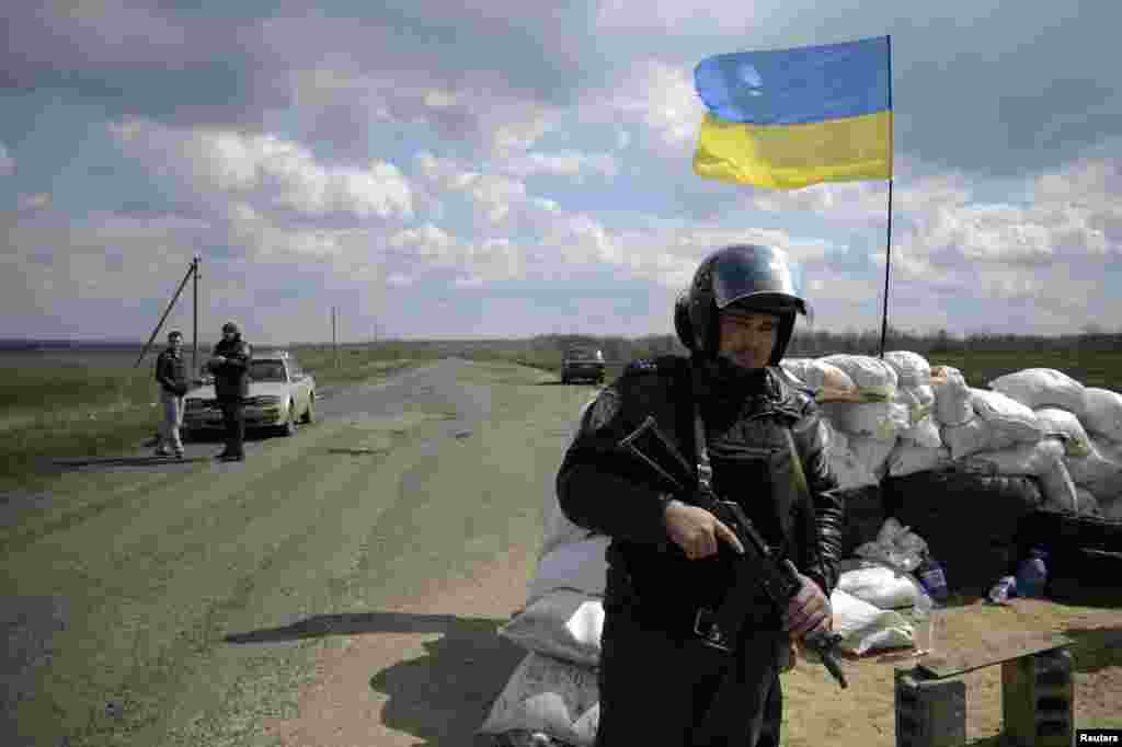 A Ukrainian soldier stands guard at a checkpoint near the city of Barvenkovo in the Kharkiv region of east Ukraine, April 15, 2014.