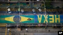 Uma estrada do Rio de Janeiro tem escrito "Hexa Brasil", pois os brasileiros esperam alcançar a sexta taça do Mundial de Futebol