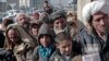 FILE - Afghan men and boys wait in line to receive donated sacks of wheat distributed by the World Food Program in Kabul, Afghanistan, Dec. 15, 2013.