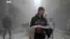 This photo provided by the anti-government activist group Aleppo Media Center (AMC), which has been authenticated based on its contents and other AP reporting, shows a Syrian man carrying the body of a child killed by a government forces airstrike in the 