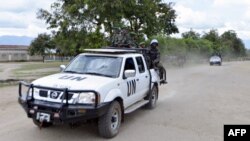 FILE - Congolese troops and UN soldiers are seen atop a truck in the town of Kiwanja.
