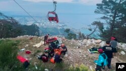 Anggota tim penyelamat dan tim darurat membantu penumpang sistem transportasi gondola di luar Antalya, selatan Turki, pada Jumat, 12 April 2024. (Foto: via AP)