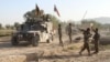 Afghan national army stand guard near the dead body of a Taliban attacker in front of the main prison building after an attack in Ghazni province, eastern Afghanistan, Monday, Sept. 14, 2015.
