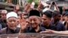 លោក Mahathir Mohamadនាយក​រដ្ឋមន្រ្តី​ម៉ាឡេស៊ី (កណ្តាល) គ្រវីដៃ​ទៅ​កាន់​ហ្វូង​មហាជន គ្រាដែល​លោក​ចាកចេញ​ពី​ព្រះវិហារ​ជាតិ ក្រោយពី​ថ្វាយ​បង្គំ​ព្រះ​នៅ​ថ្ងៃសុក្រ ក្នុង​ទីក្រុង គូឡាឡាំពួ ប្រទេស​ម៉ាឡេស៊ី នៅ​ថ្ងៃទី ១១ ខែឧសភា ឆ្នាំ២០១៨។