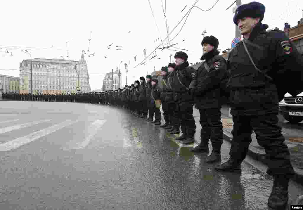 Riot police stand guard during a march by opposition supporters to commemorate Kremlin critic Boris Nemtsov, who was shot dead on Friday night, in Moscow, March 1, 2015. 