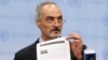 Syrian U.N. Ambassador Bashar Ja'afari shows a document to reporters at the United Nations Headquarters in New York, Sept. 12, 2013.