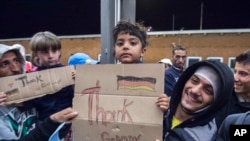 FILE - Refugees are seen arriving at the train station in Saalfeld, central Germany, Sept. 5, 2015.