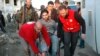 In this photo taken on Feb. 9, 2014, and released by the Syrian official news agency SANA, Syrian Arab Red Crescent members in red uniforms help evacuate an injured man on a bus out of the battleground city of Homs.
