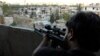 A Free Syrian Army fighter looks through the scope of his sniper rifle at an area controlled by forces loyal to Syria's President Bashar al-Assad in Aleppo's Al-Ezaa neighborhoo,d Sept. 11, 2013.