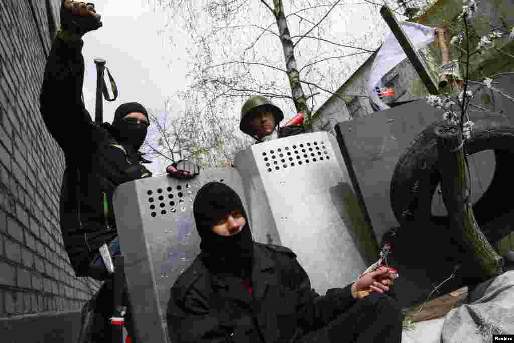 Pro-Russian protesters sit at barricades at the police headquarters in Slaviansk, April 15, 2014.