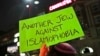 Sebuah poster bertuliskan "Warga Yahudi yang menentang Islamofobia" diacungkan oleh seorang demonstran dalam aksi protes di dekat kampus Universitas Harvard pada 7 Maret 2017. (Foto: AP/Charles Krupa)