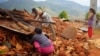 Residents of a destroyed home in Ratomatey scavenge for corn in the rubble.