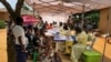 FILE - A woman and her children wait to receive Ebola vaccinations, in the village of Mabalako, in eastern Congo Monday, June 17, 2019. 