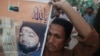 FILE - A supporter of a religious political party holds a banner of convicted killer Mumtaz Qadri during a demonstration against Qadri's sentence, in Karachi, March 9, 2015. 