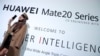 一名模特站在华为在英国伦敦发起的华为Mate20系列的广告牌前。（2018年10月16日）
